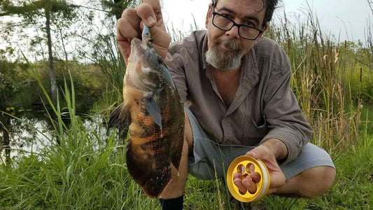 Man holding a freshwater fish on one hand and a Yoyito handline fishing reel on the other hand