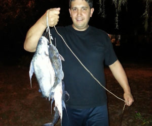 Man holding a fishing line showing the fish he catched