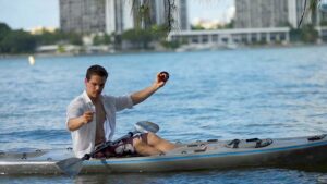 Man sitting on a kayak with a hand line reel on his hand